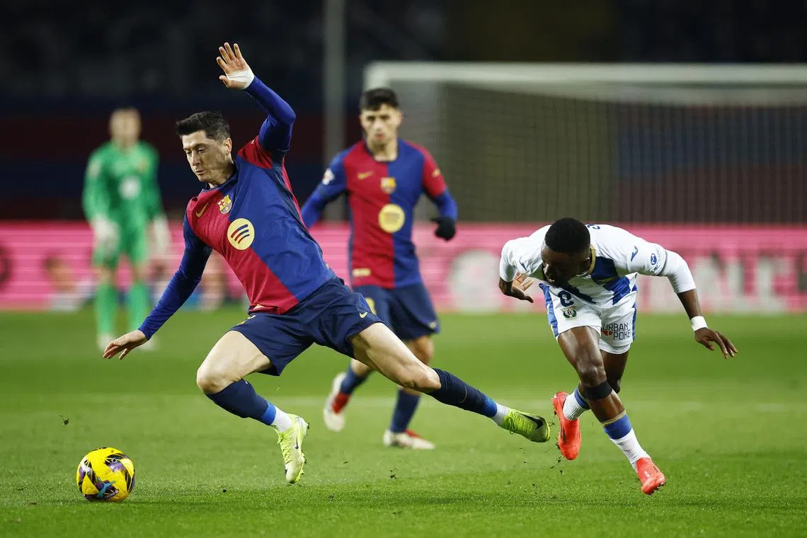 FILE PHOTO: Soccer Football - LaLiga - FC Barcelona v Leganes - Estadi Olimpic Lluis Companys, Barcelona, Spain - December 15, 2024  Leganes' Seydouba Cisse in action with FC Barcelona's Robert Lewandowski REUTERS/Albert Gea/File Photo