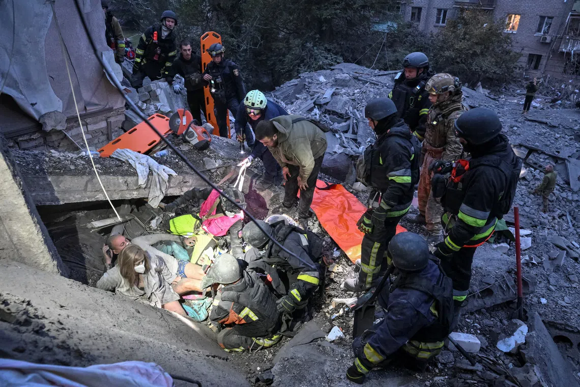 Rescuers finding two residents amid the rubble of an apartment building hit by a Russian air strike in Zaporizhzhia, Ukraine, on Oct 10.