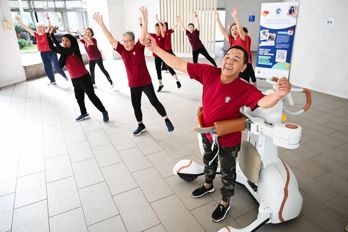 Stroke survivor Leow Cher Hwa (right), 66, using a wearable robot to exercise during a Zumba class at his active ageing centre in Tampines.
