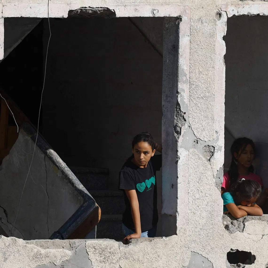 Palestinian children watch from a damaged house as rescuers work at the site of a nearby residential building that had been damaged in an earlier Israeli strike during the war and collapsed on Wednesday, in Gaza City, September 16, 2026. REUTERS/Mahmoud Issa