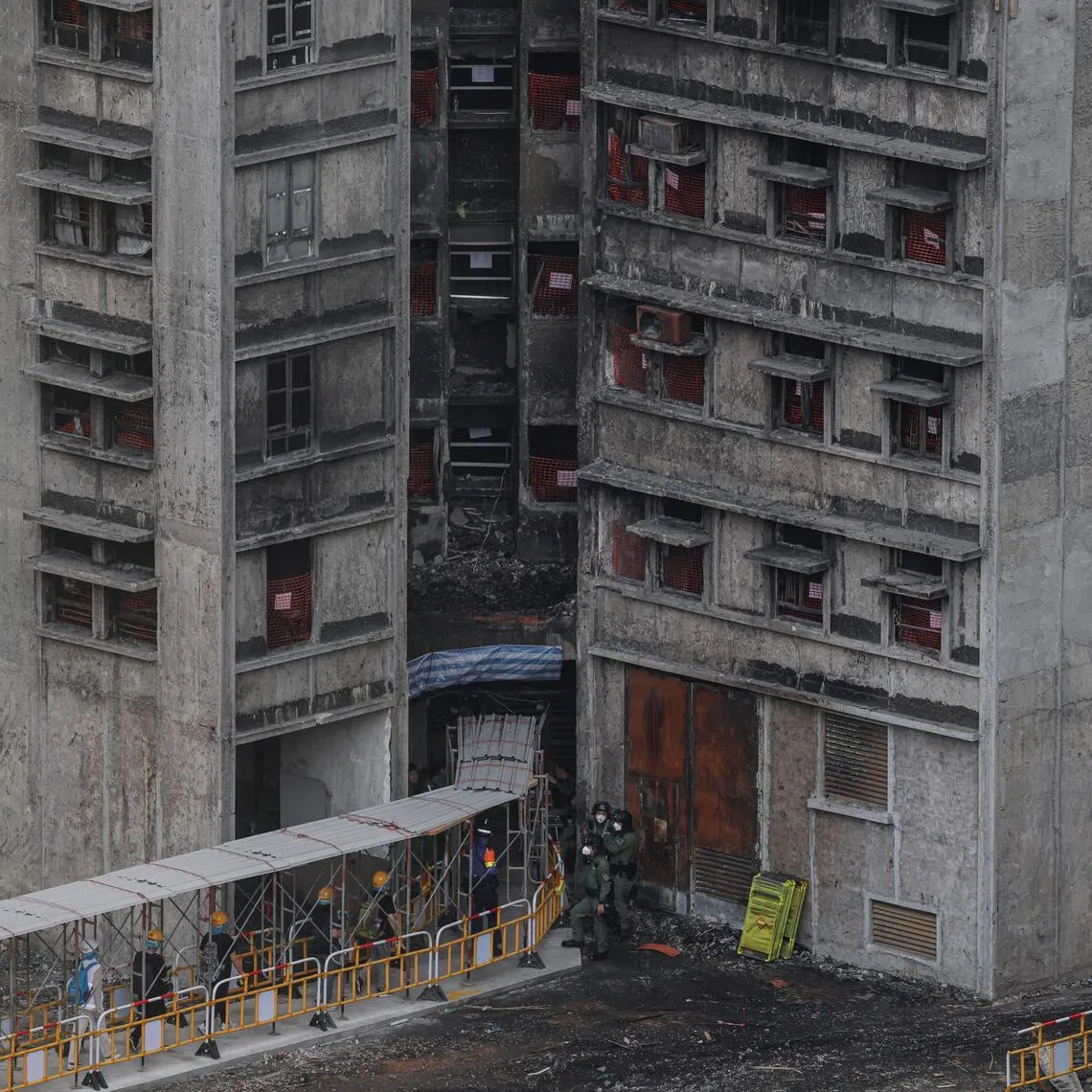 Residents walk towards a building at Wang Fuk Court to retrieve personal belongings, in Hong Kong, China, on April 21.