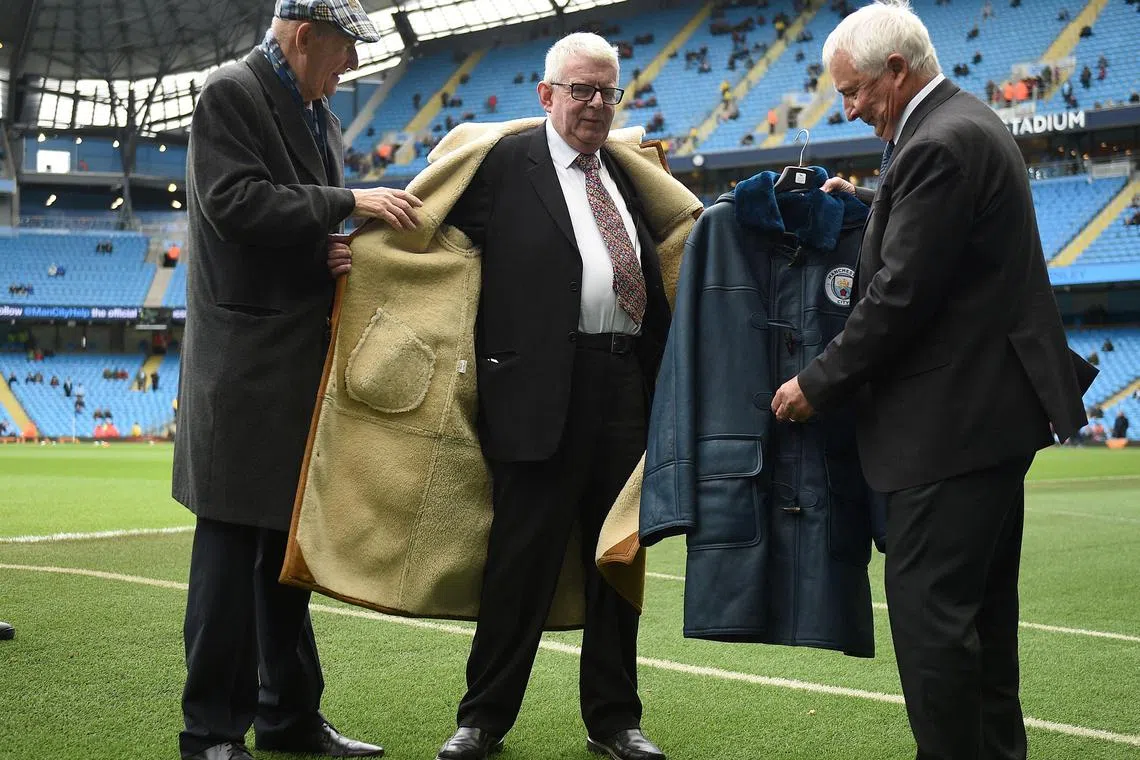 Football commenatator John Motson (centre), who died on Thursday, being presented with a Manchester City branded coat ahead of the game between Manchester City and Burnley in 2017.
