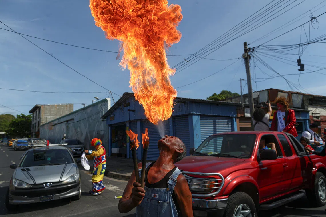 A performer spitting fire during a parade marking National Clown Day in San Salvador, El Salvador, on Dec 3, 2025. 