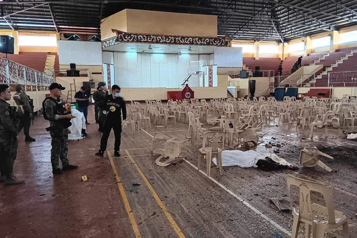 Law enforcement officers investigate the scene of an explosion that occurred during a Catholic Mass in a gymnasium at Mindanao State University in Marawi, Philippines, on December 3, 2023.