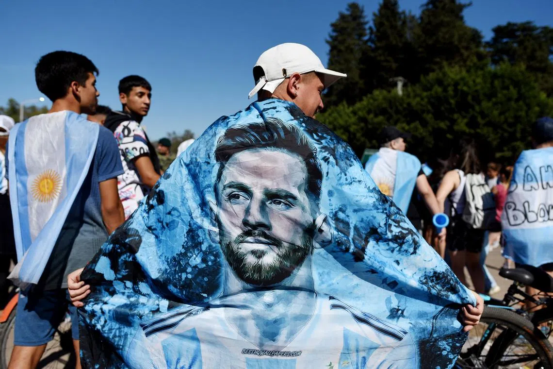 An Argentina fan displays a flag of Lionel Messi at the victory parade, Dec 20, 2022. 