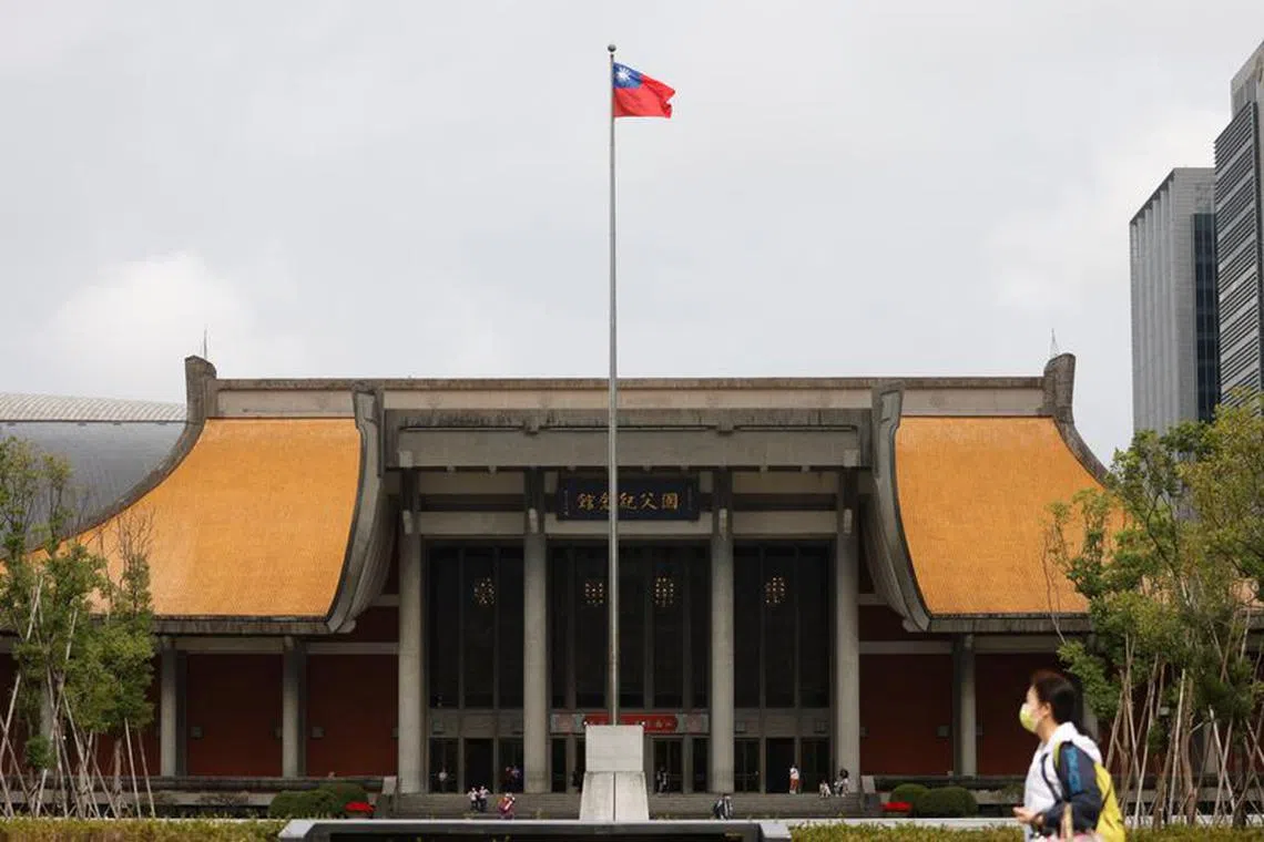 FILE PHOTO: People walk near a fluttering Taiwanese flag outside the Sun Yat-Sen Memorial Hall in Taipei, Taiwan November 16, 2023. REUTERS/Carlos Garcia Rawlins/File Photo