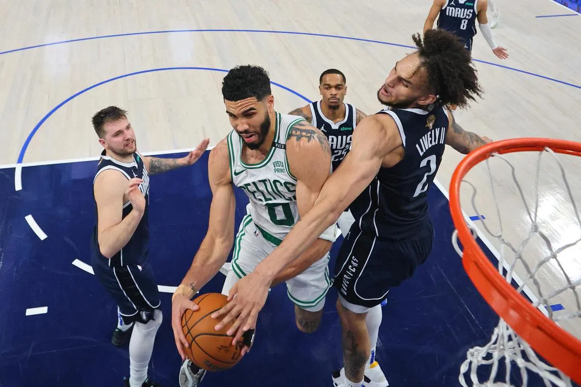 Boston Celtics forward Jayson Tatum battling for the ball against Dallas Mavericks center Dereck Lively II during game three of the 2024 NBA Finals.