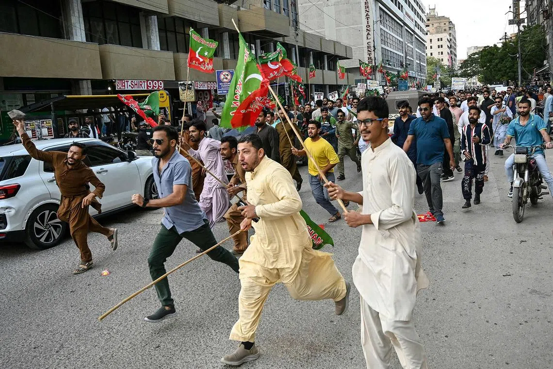 TOPSHOT - Supporters of Pakistan’s opposition Pakistan Tehreek-e-Insaf (PTI) party clash with police as they protest against a hike in fuel prices in Karachi on April 5, 2026. Pakistan drastically raised fuel prices in response to spiking global prices caused by the Iran war, the country's petroleum minister said. (Photo by Asif HASSAN / AFP)