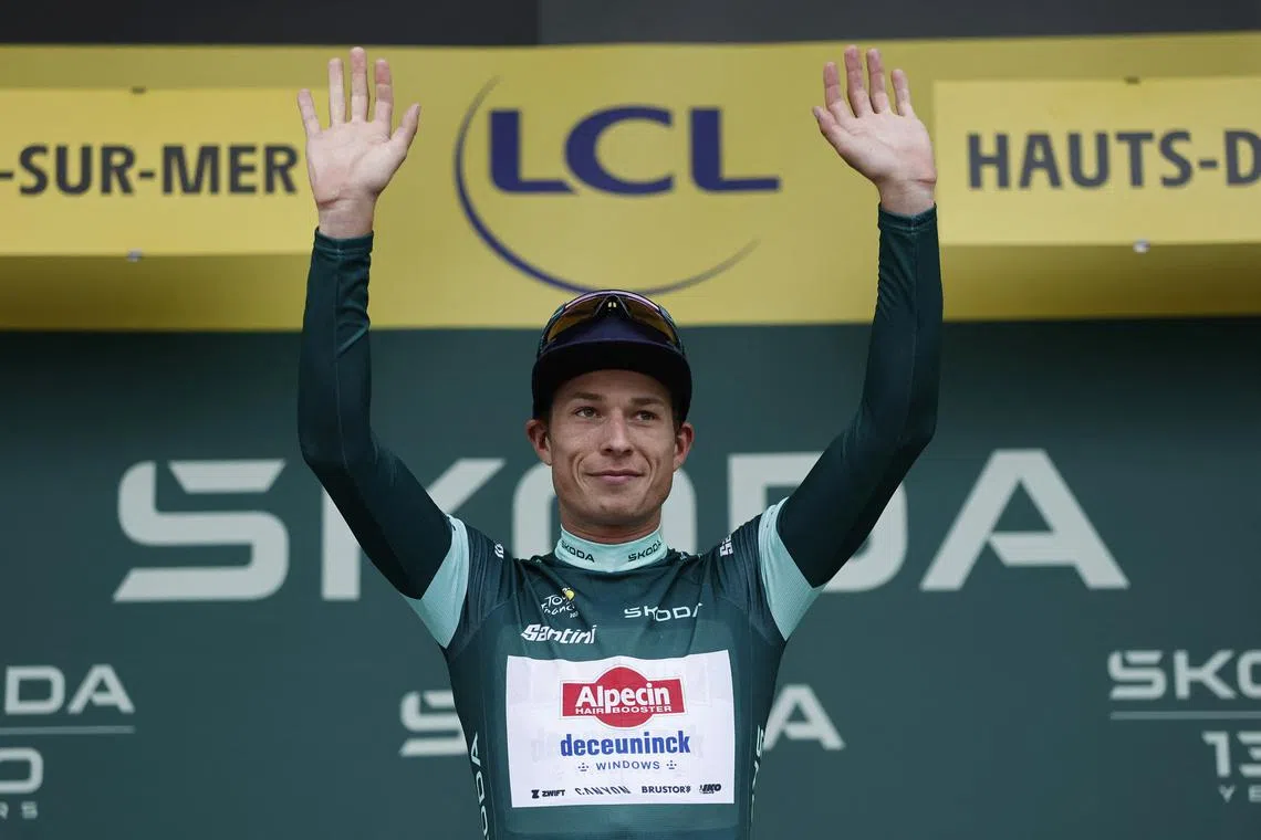 FILE PHOTO: Cycling - Tour de France - Stage 2 - Lauwin-Planque to Boulogne-sur-Mer - Boulogne-sur-Mer, France - July 6, 2025 Alpecin-Deceuninck's Jasper Philipsen celebrates on the podium wearing the green jersey after winning stage 2 REUTERS/Benoit Tessier/File Photo