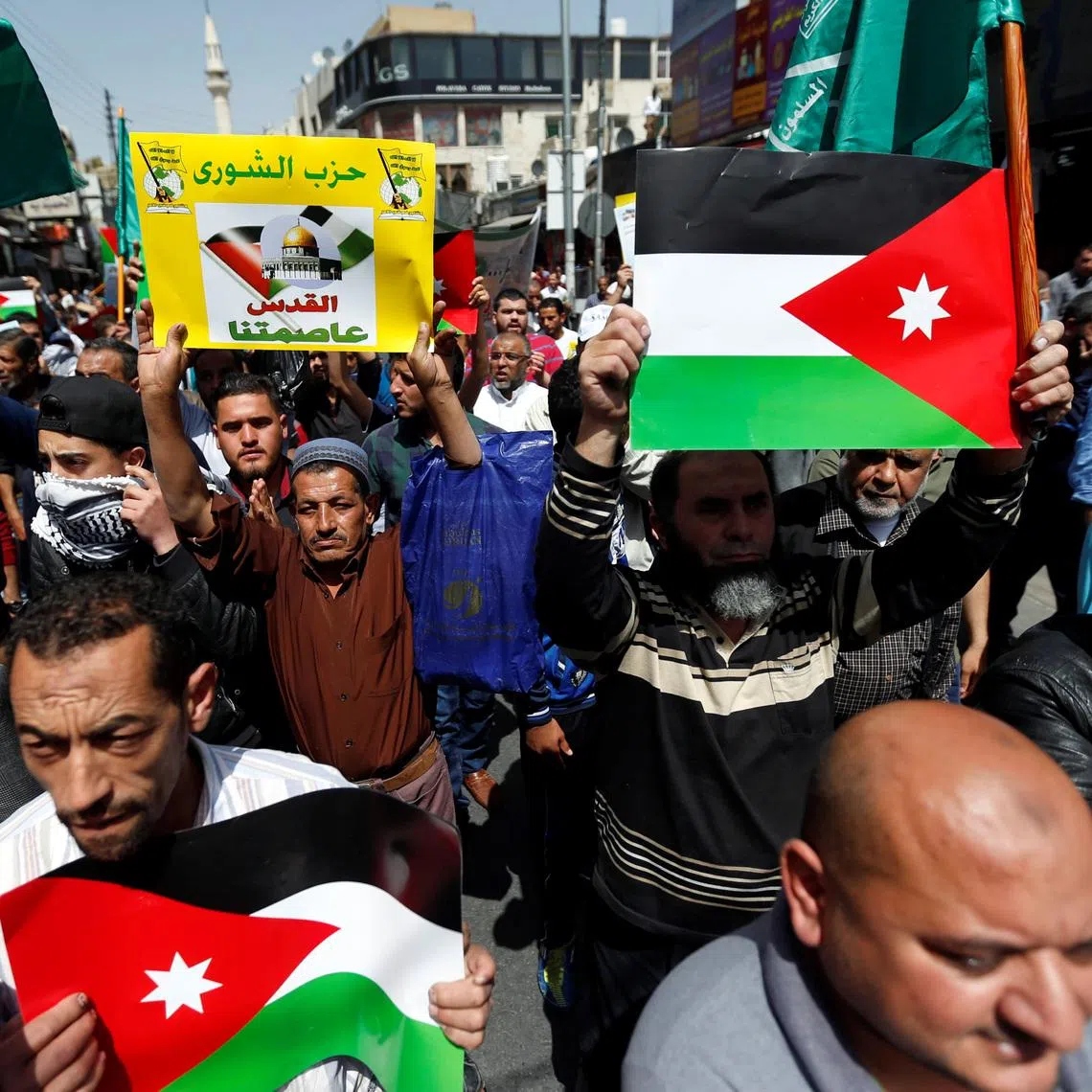 Supporters of the Muslim Brotherhood hold Jordanian flags and chant slogans during a pro-Palestinian demonstration after Friday prayers in Amman, Jordan, April 13, 2018. The placard reads: \"Jerusalem our capital\". REUTERS/Muhammad Hamed