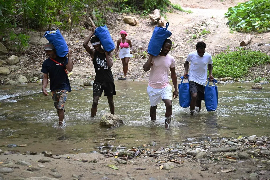 Wilfrank Liendo (second from right) and other locals carry supplies donated by the World Food Programme to their home in Chichiriviche de la Costa, La Guaira state, Venezuela, on July 16, following the June 24 earthquakes.