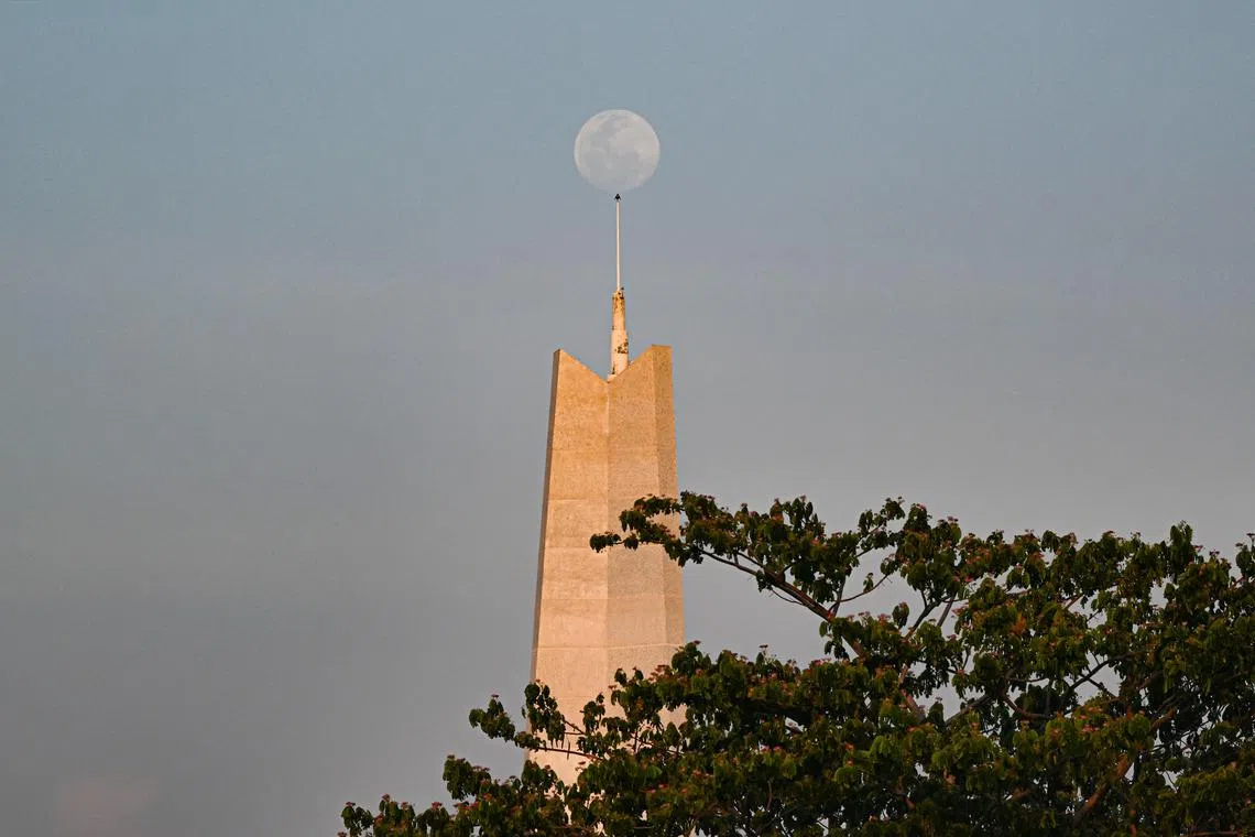 Moon raising above the Win-Win Memorial outside the entrance of the Olympic Park in Phnom Penh, Cambodia on May 4, 2023. Cambodia will be hosting the 32nd SEA Games from May 5 till May 17, 2023
