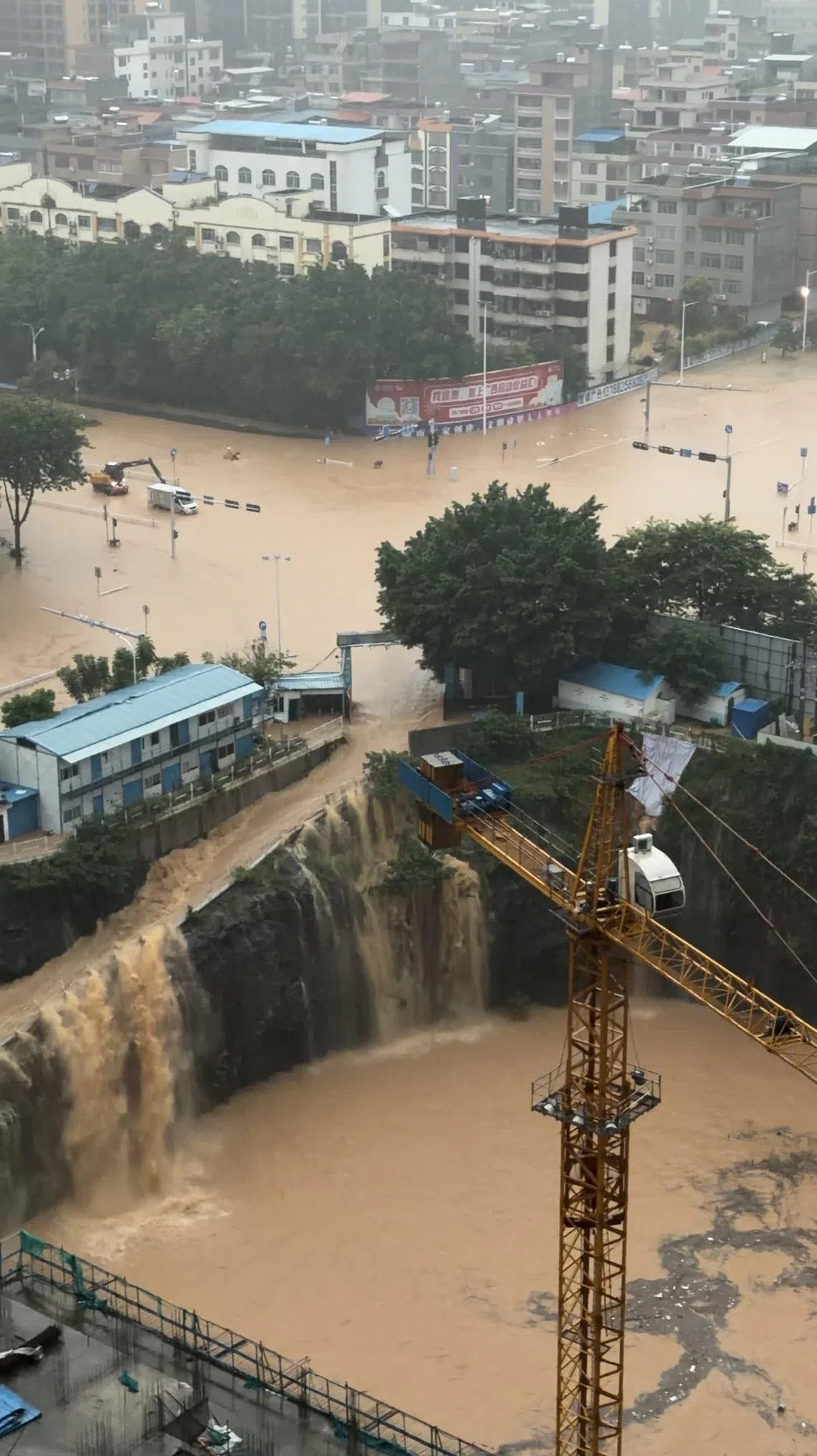 Floodwater flows down the side of a ramp at a construction site, amid heavy rain brought by Typhoon Maysak, in Guigang, Guangxi Zhuang Autonomous Region, China, in this still image obtained from social media video.  Social Media/via REUTERS