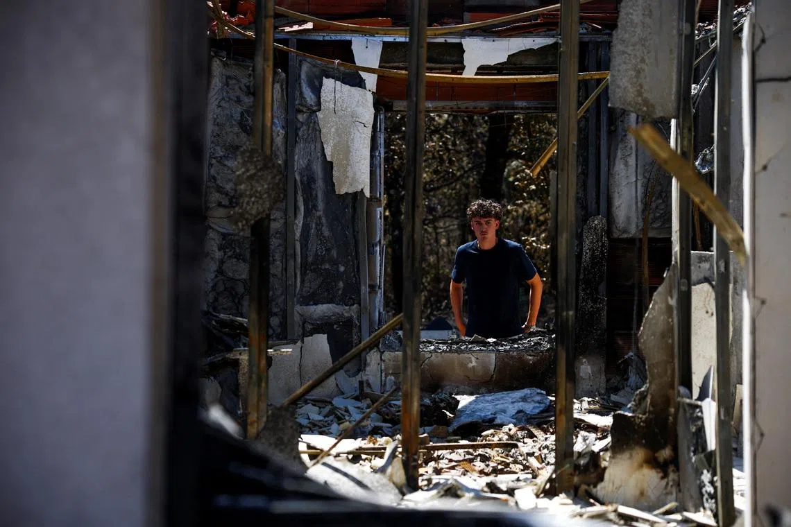 Raphael Fohanno, 18, looks at his burnt family home near a forest affected by a wildfire, in Biscarrosse, Landes department, amid drought conditions, a new heatwave warning, and water shortages across much of France, July 28, 2026. REUTERS/Sarah Meyssonnier