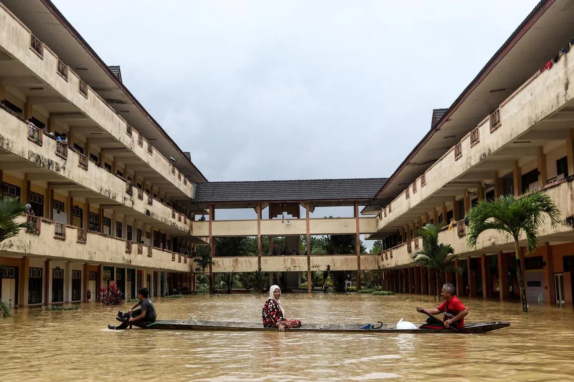 Residents are rescued by a boat from the flood relief centre as the flood water rise and partially submerged the building at Dungun, Terengganu on Dec 21, 2022. 