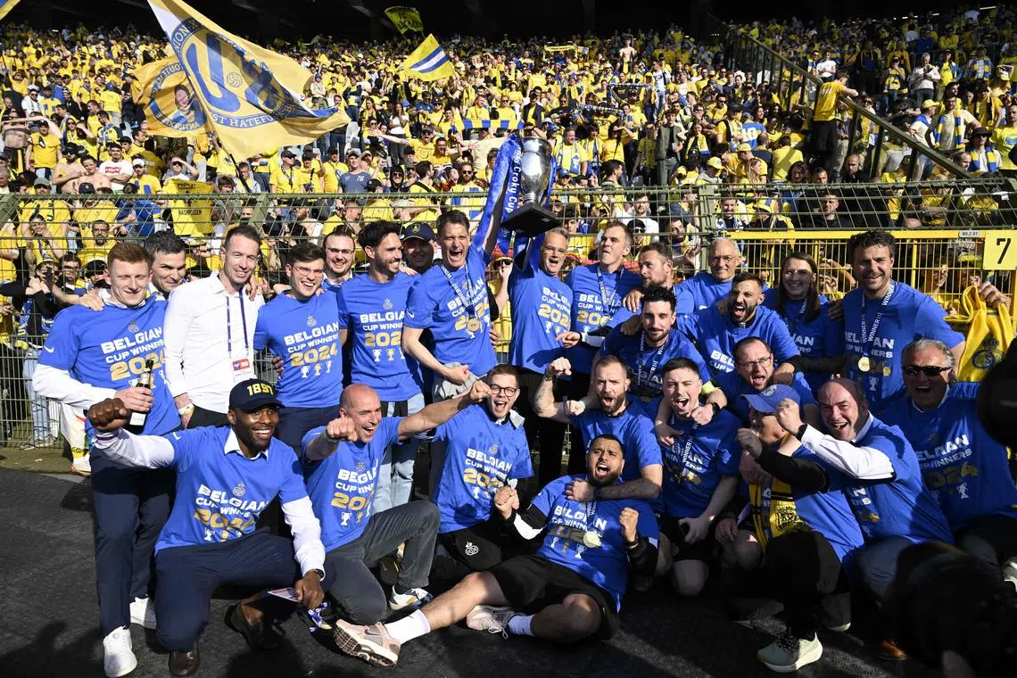 Union Saint-Gilloise's head coach Alexander Blessin (centre) and team members celebrate with the trophy after winning the Belgian Cup final against Royal Antwerp at the King Baudouin Stadium in Brussels on May 9, 2024.