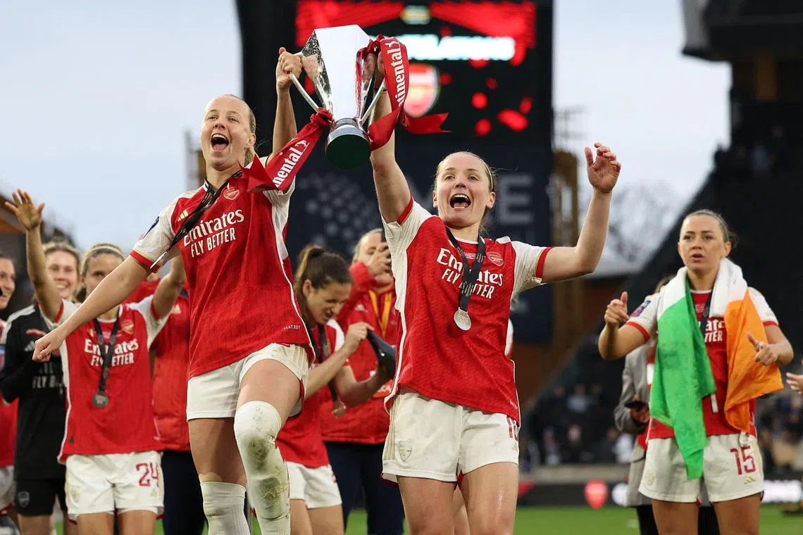 Arsenal's English striker Beth Mead (centre, left) and Scottish midfielder Kim Little (centre, right) holding the League Cup trophy after their 1-0 win over Chelsea at Molineux on March 31.