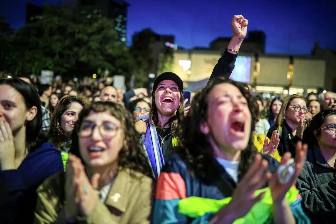 People react as they watch news coverage of the release of three female hostages who have been held in Gaza since the Oct 7 2023 attack.