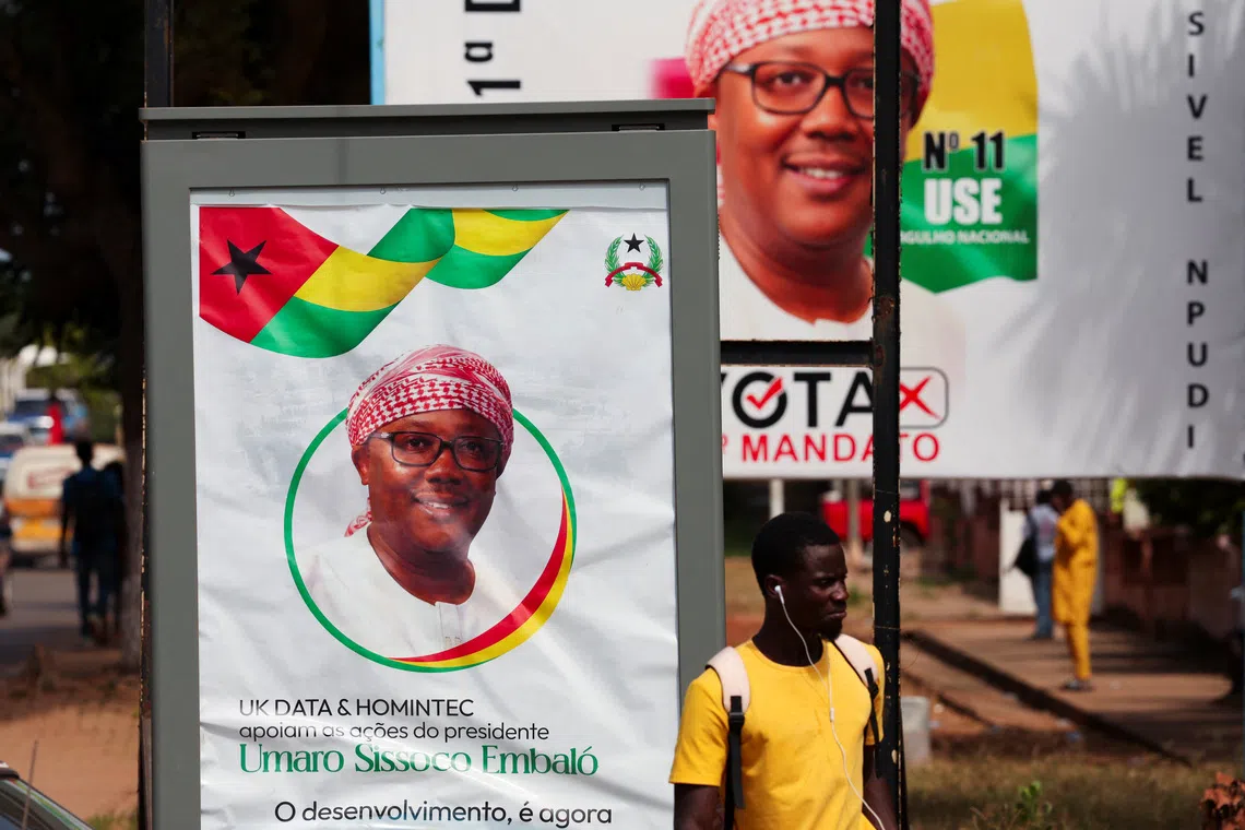 A man stands near campaign billboards of Guinea-Bissau's outgoing President Umaro Sissoco Embalo, ahead of the presidential election scheduled for November 23, in Bissau, Guinea-Bissau November 20, 2025. REUTERS/Luc Gnago