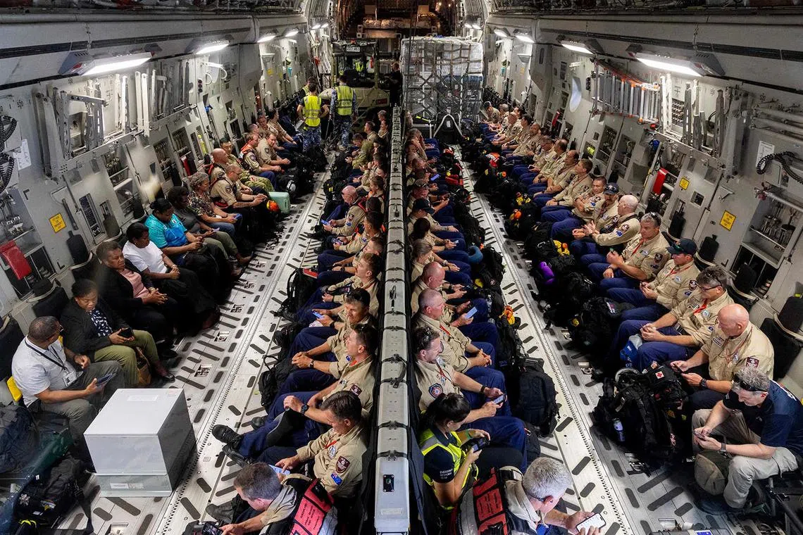 TOPSHOT - A handout photo taken on December 18, 2024 and received from the Australian Department of Defence shows disaster assistance response team personnel onboard a Royal Australian Air Force C-17A Globemaster III bound for Vanuatu at RAAF Base Amberley in Queensland. Rescue teams dug for survivors trapped in crumpled buildings in the Pacific nation of Vanuatu on December 18 after a powerful earthquake killed at least nine people, burying some in rubble and landslides. Australia and New Zealand flew in medical and search-and-rescue personnel on military transport aircraft -- including a 64-person Australian team with two search dogs. (Photo by Campbell Latch / AUSTRALIAN DEPARTMENT OF DEFENCE / AFP) / RESTRICTED TO EDITORIAL USE - MANDATORY CREDIT "AFP PHOTO / AUSTRALIAN DEPARTMENT OF DEFENCE/ CAMPBELL LATCH" - NO MARKETING - NO ADVERTISING CAMPAIGNS - DISTRIBUTED AS A SERVICE TO CLIENTS