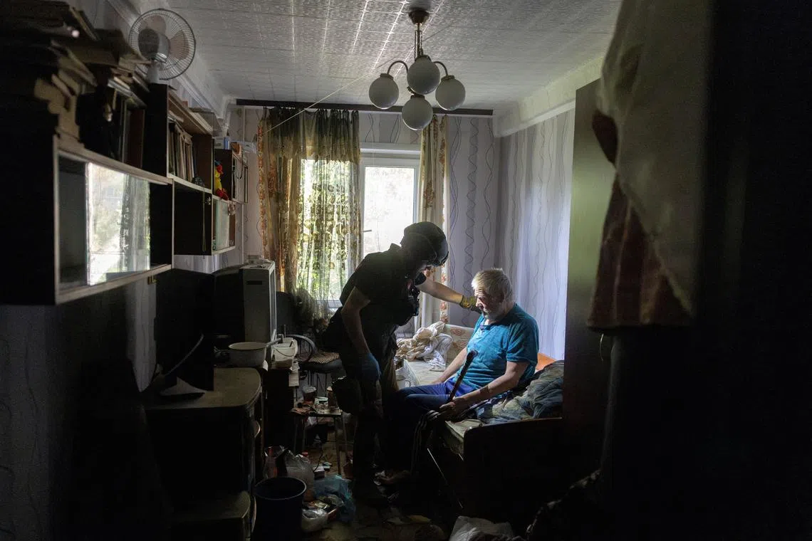FILE PHOTO: A volunteer of East SOS assists resident Andrii Ostorozhnyi who is evacuating his home because of Russian advances, amid Russia's attack on Ukraine, in Selydove near Pokrovsk, Ukraine, August 22, 2024. REUTERS/Thomas Peter/File photo