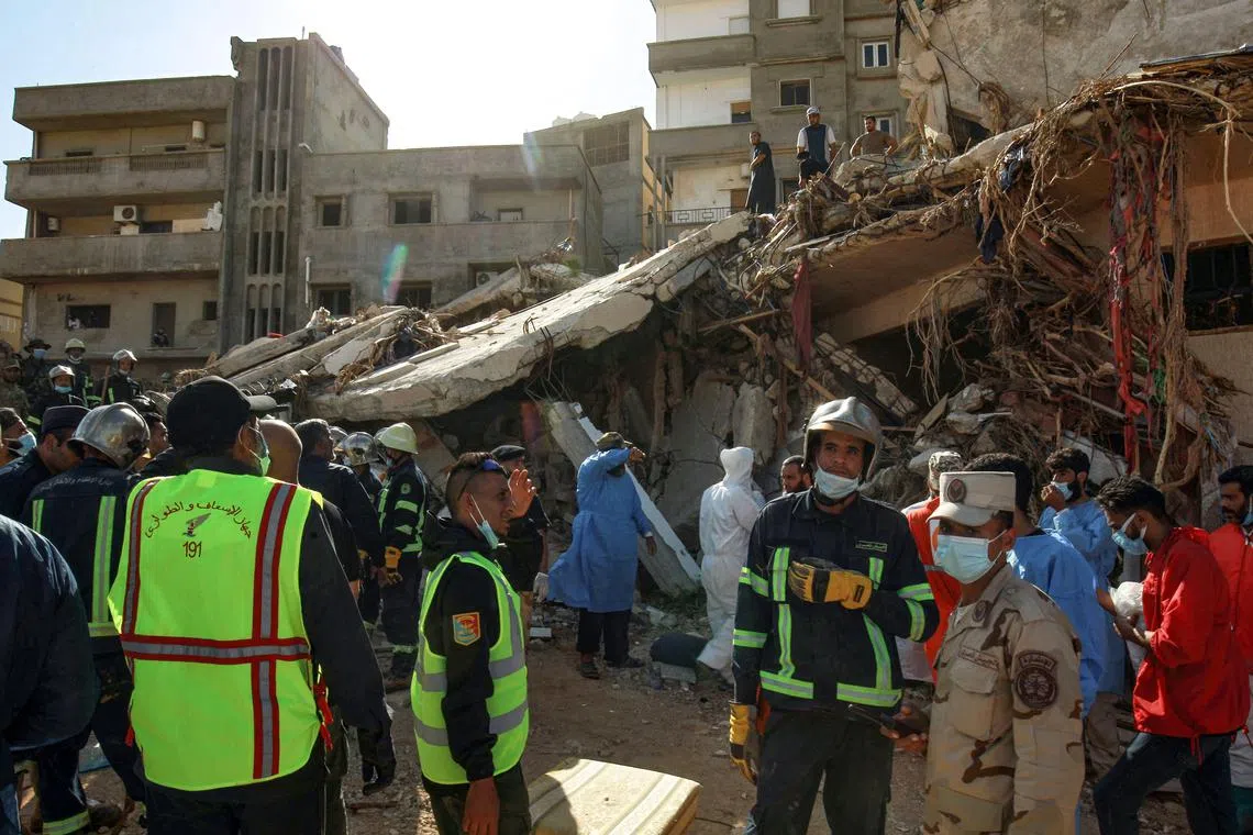 Rescuers gathering in front of buildings that collapsed during floods in Derna, Libya, on Sept 14.