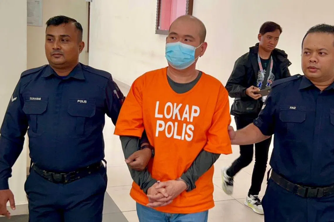 Soh Kian Hui (centre), used a cane to damage the rear windscreen of a Toyota Fortuner after a heated argument with another driver.