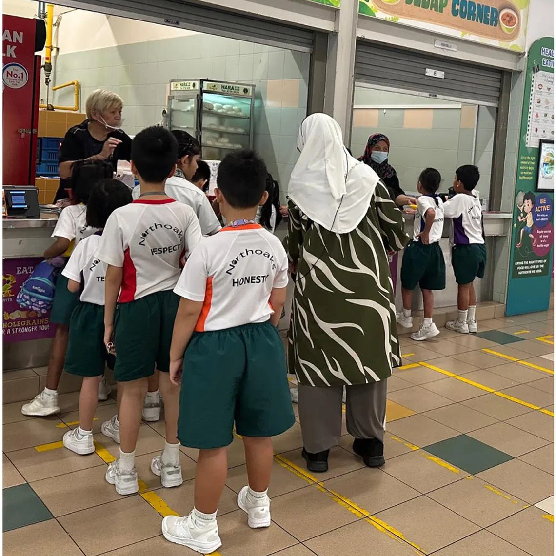 Northoaks Primary School and Kranji Primary School students eating their meals during recess time.