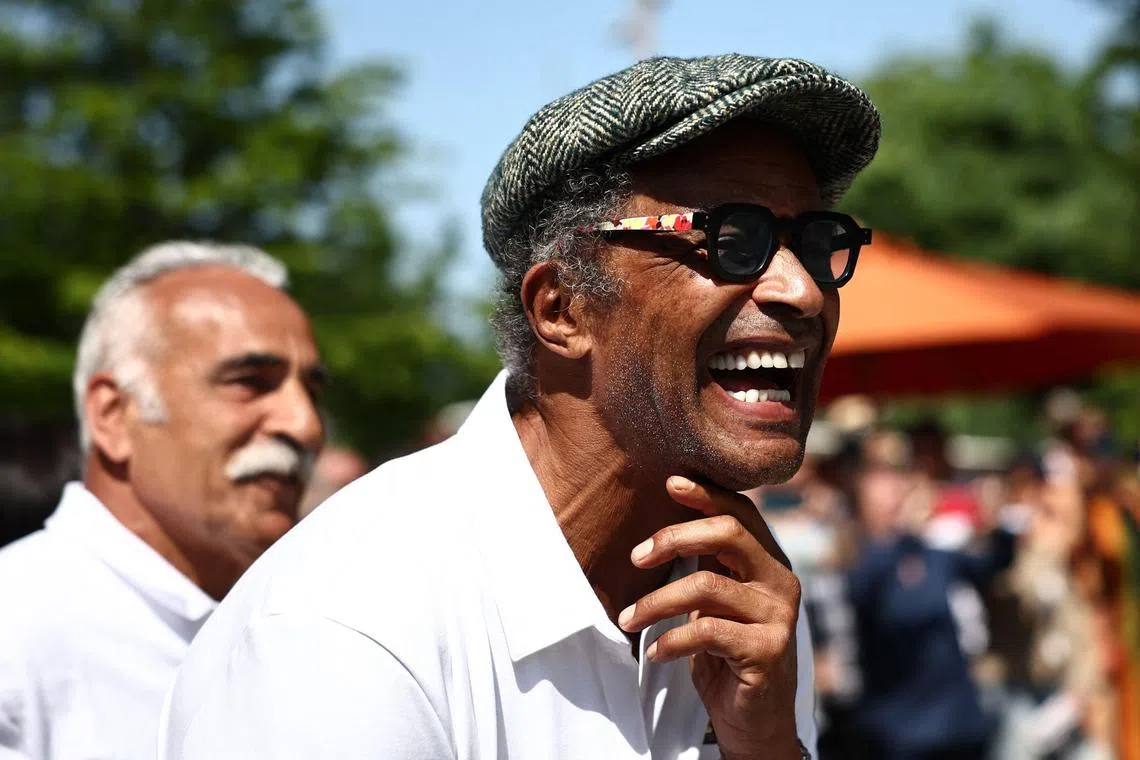 Former French tennis player and singer Yannick Noah (front) laughing past former Iranian tennis player Mansour Bahrami during the inauguration of a fresco retracing his life, on the occasion of the 40th anniversary of his victory at Roland Garros in 1983, on day one of the Roland-Garros Open tennis tournament in Paris on Sunday.