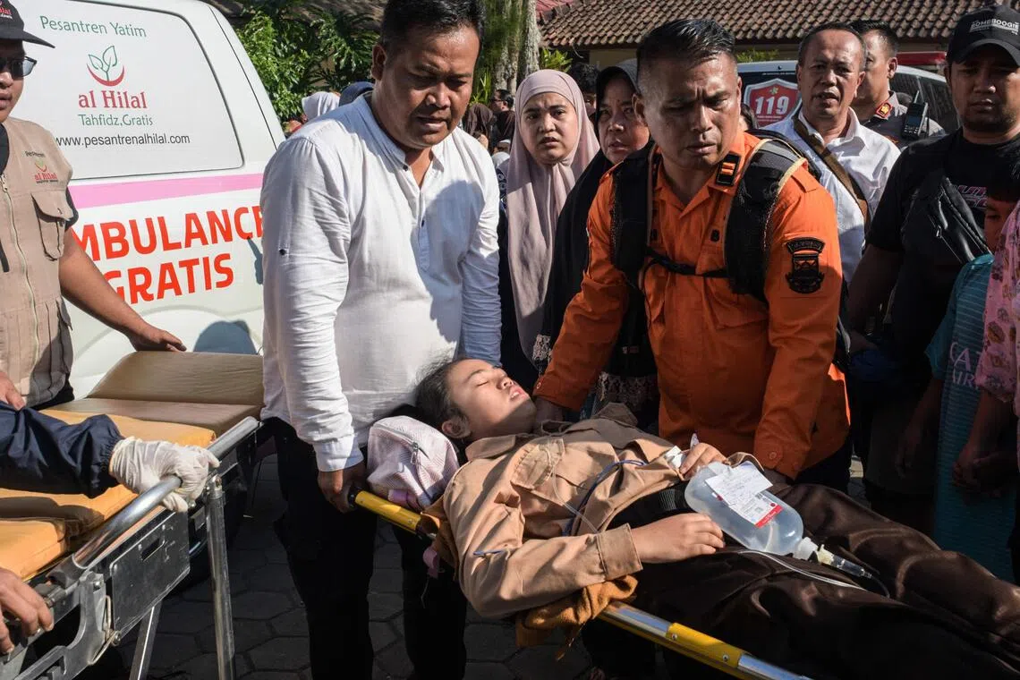 A student is carried on a stretcher after suffering from food poisoning at Cisarua Junior High School in Bandung, West Java, on Oct 14, 2025.