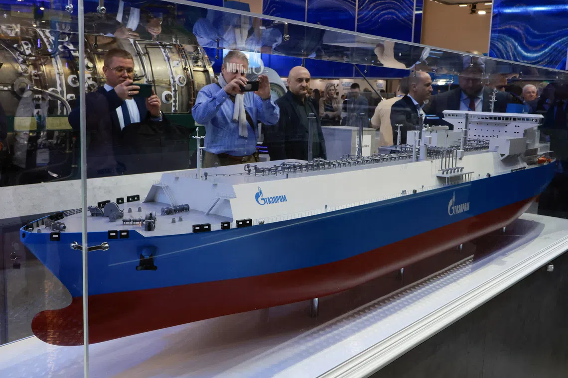 People take photos of a model of an LNG carrier with the logo of Gazprom company at the Saint Petersburg international gas forum in Saint Petersburg, Russia October 8, 2025.  REUTERS/Anton Vaganov