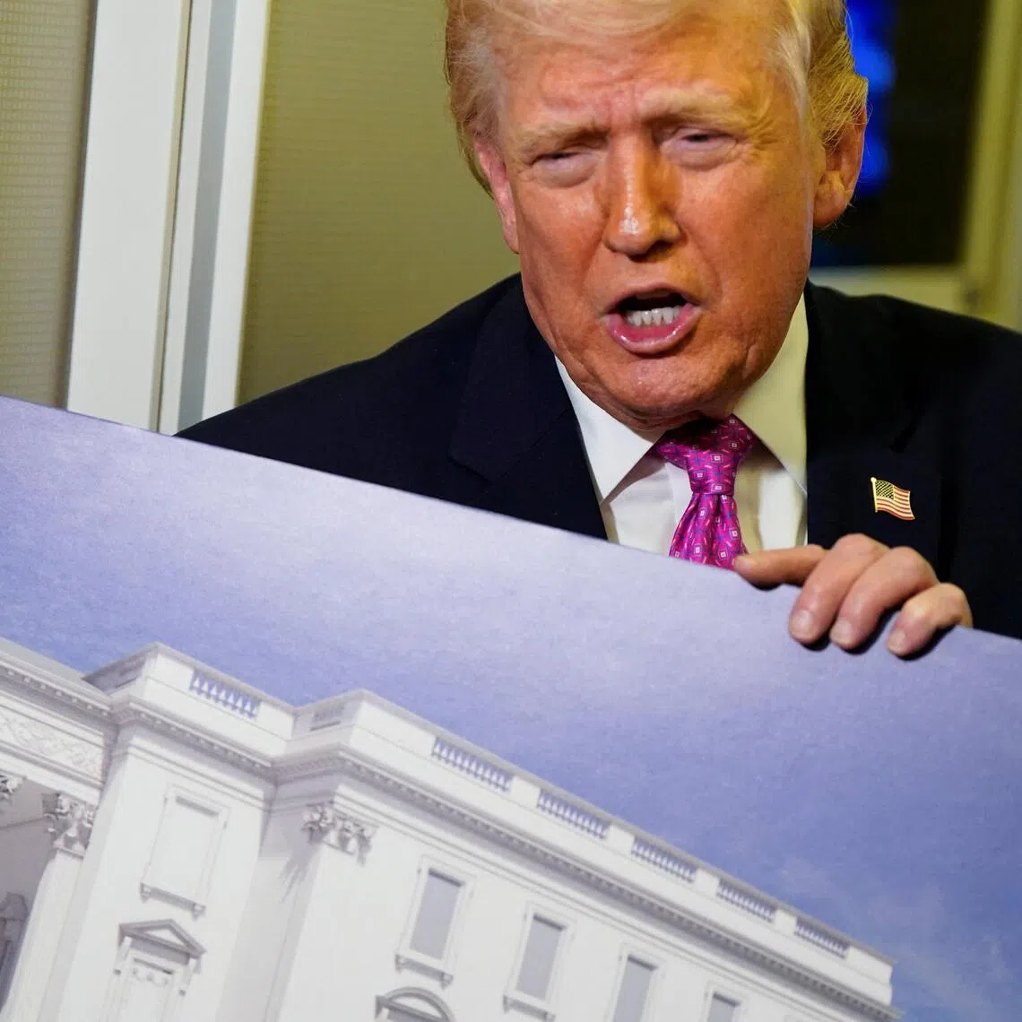 US President Donald Trump talking to members of the media on March 29, aboard Air Force One, while holding up renderings of the planned White House ballroom.