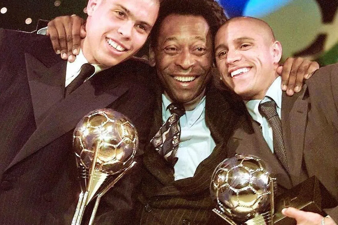 In this file photo taken on January 12, 1998 Brazilian soccer players Ronaldo (L) and Roberto Carlos (R) joke with Brazilian Sports Minister Pele (C), at Eurodisney leisure park in Marne la Vallee, after being elected 1st and 2nd players respectively of the year 97 by the Federation Internationale de Football Association (FIFA). 