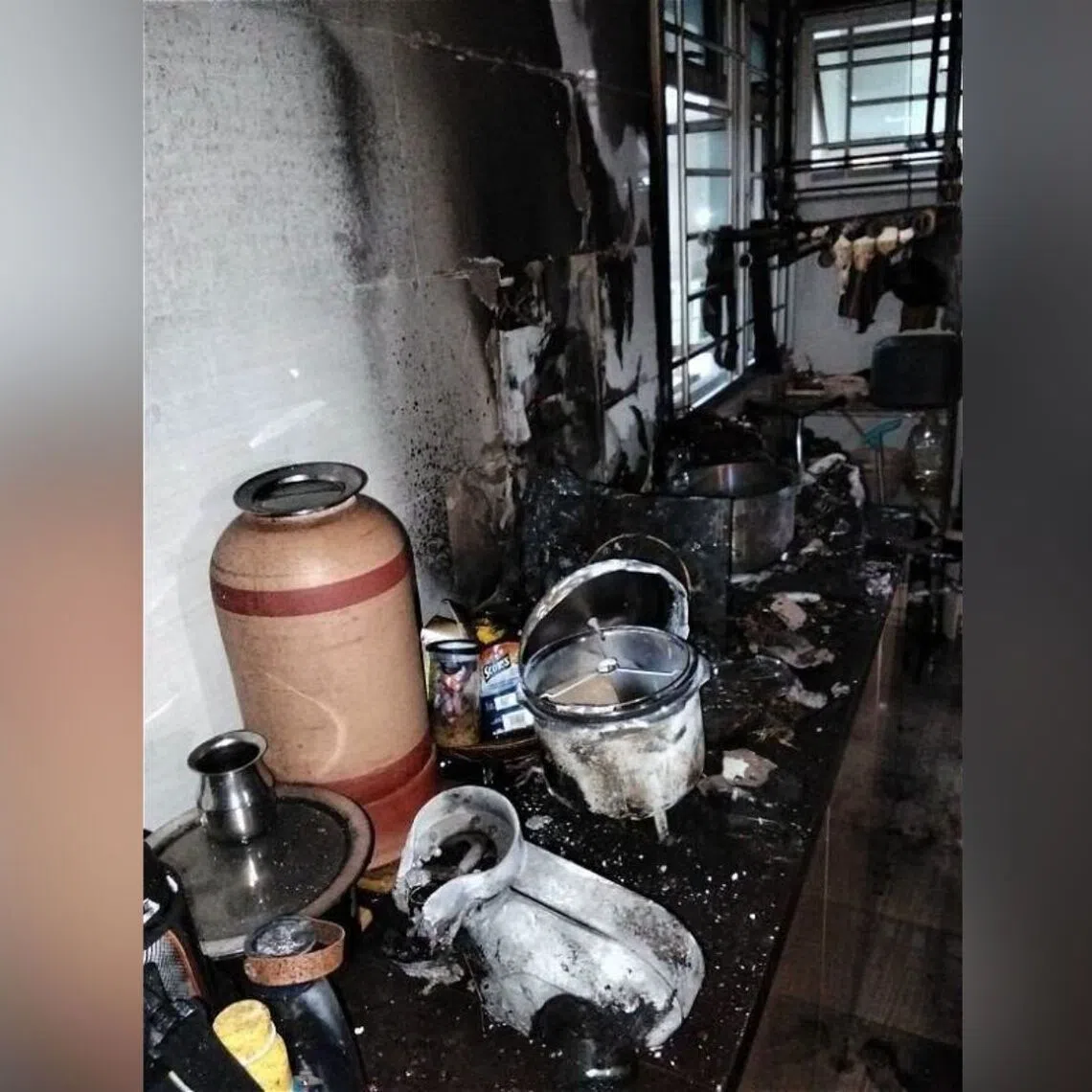 Blackened walls and deformed utensils seen in the kitchen of the flat where a fire broke out on Aug 18.