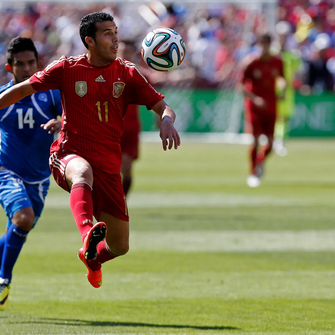 Jun 7, 2014; Landover, MD, USA; Spain midfielder Pedro Rodriguez (11) receives a pass in front of El Salvador forward Andres Flores (14) in the first half at FedEx Field. Spain won 2-0. Mandatory Credit: Geoff Burke-USA TODAY Sports