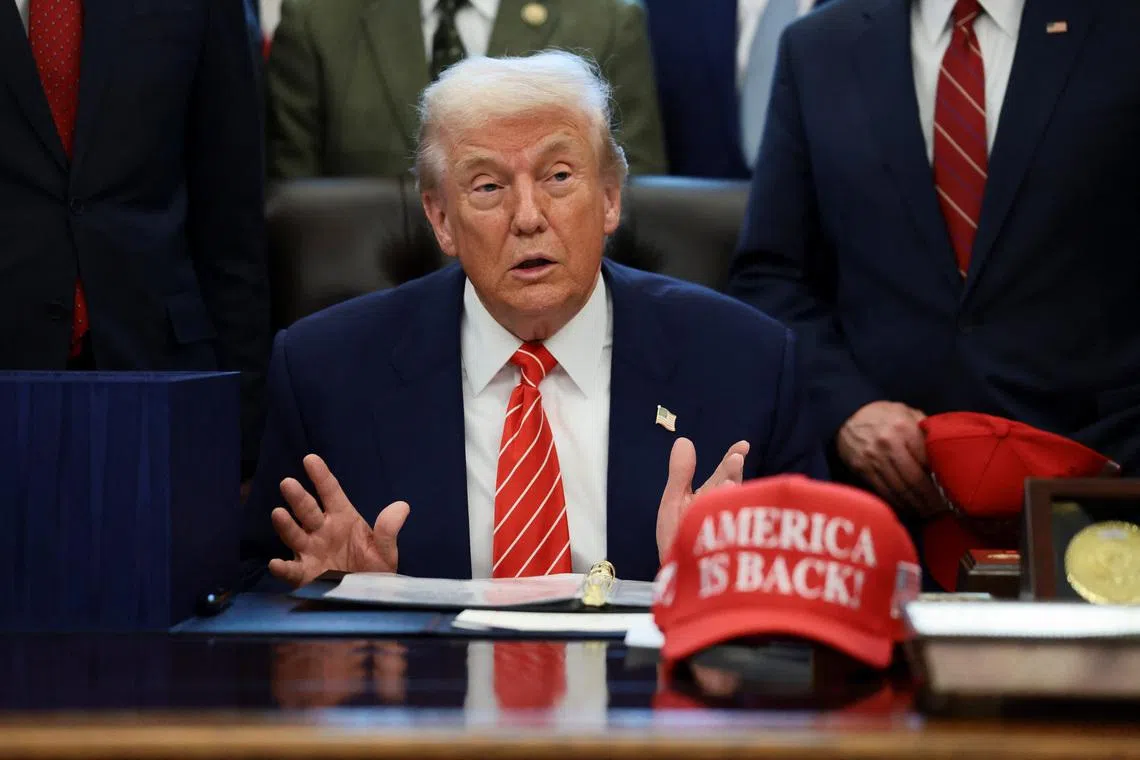 U.S. President Donald Trump sits at his desk, behind a hat that reads \"America is back\" at the White House in Washington, D.C., U.S., February 3, 2026. REUTERS/Evelyn Hockstein/File Photo