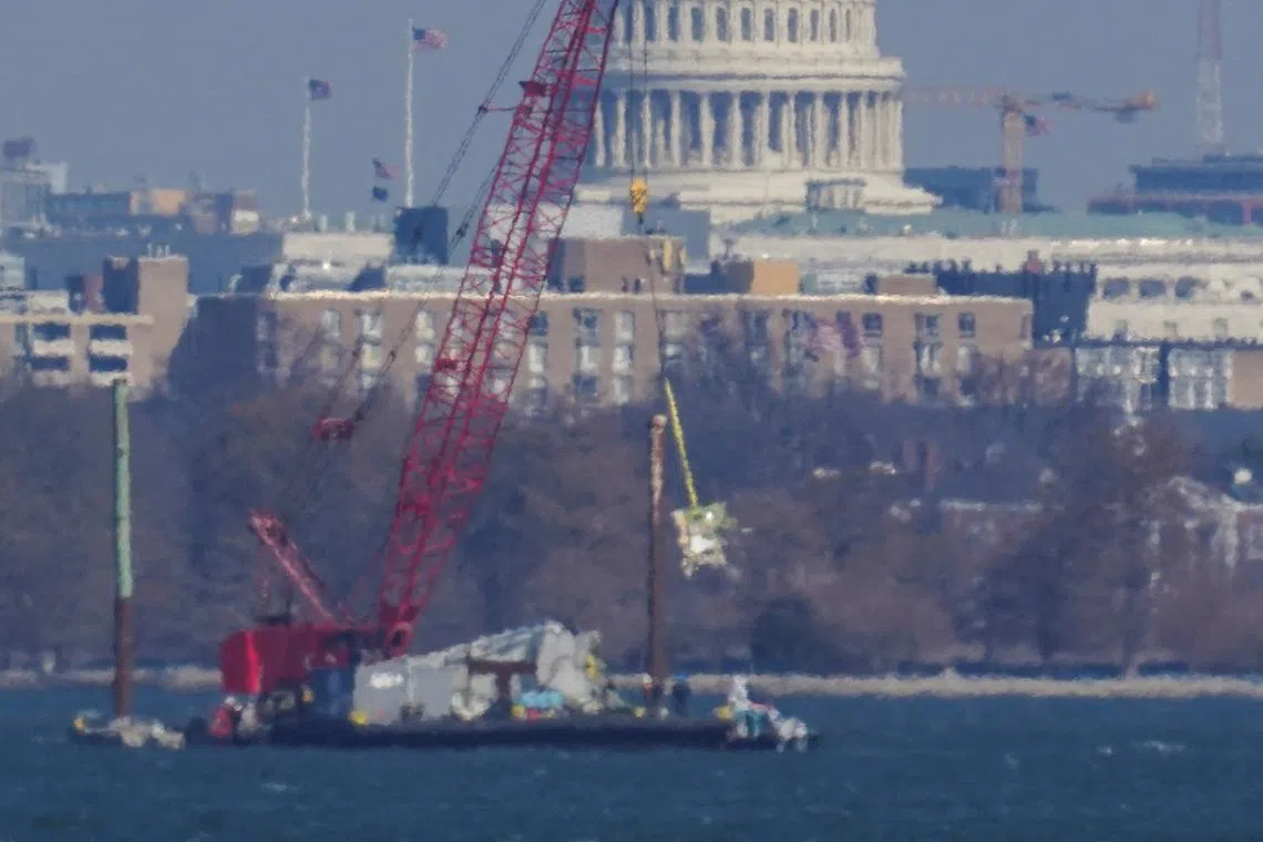 FILE PHOTO: Crews work to retrieve the wreckage of American Eagle flight 5342 in the Potomac River, in the aftermath of the collision of American Eagle flight 5342 and a Black Hawk helicopter that crashed into the river, with the Capitol dome in the background, as seen from Virginia, U.S., February 4, 2025.REUTERS/Nathan Howard/File Photo