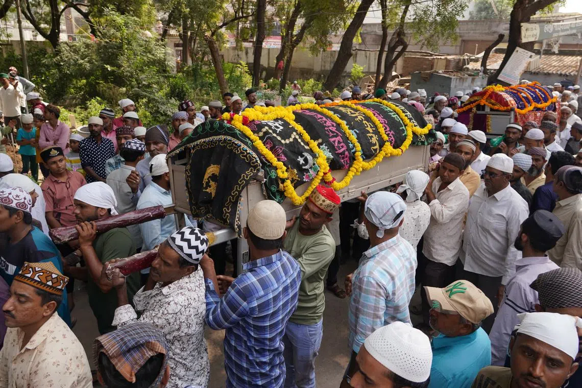 People carrying the bodies of victims of the bridge collapse in Morbi, Gujarat state, India, on Oct 31, 2022.