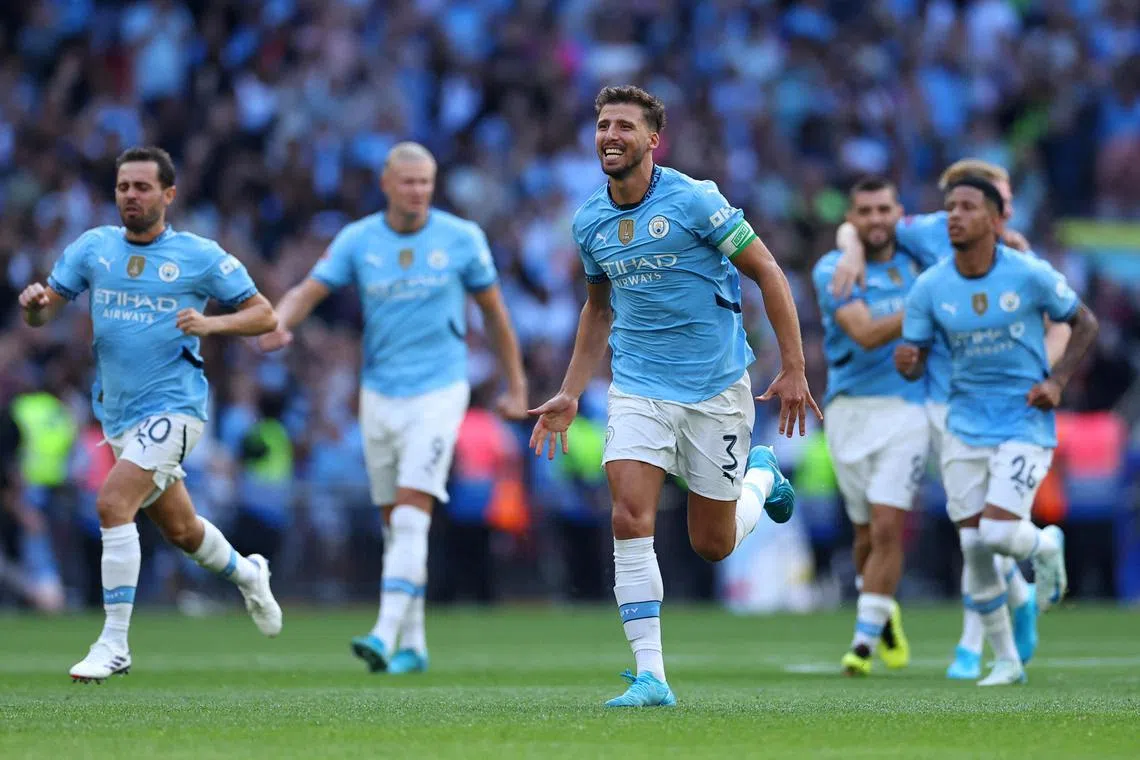 Manchester City's Ruben Dias celebrating with his teammates after beating Manchester United 7-6 win on penalties to win  the Community Shield at Wembley on Aug 10. The match ended 1-1.