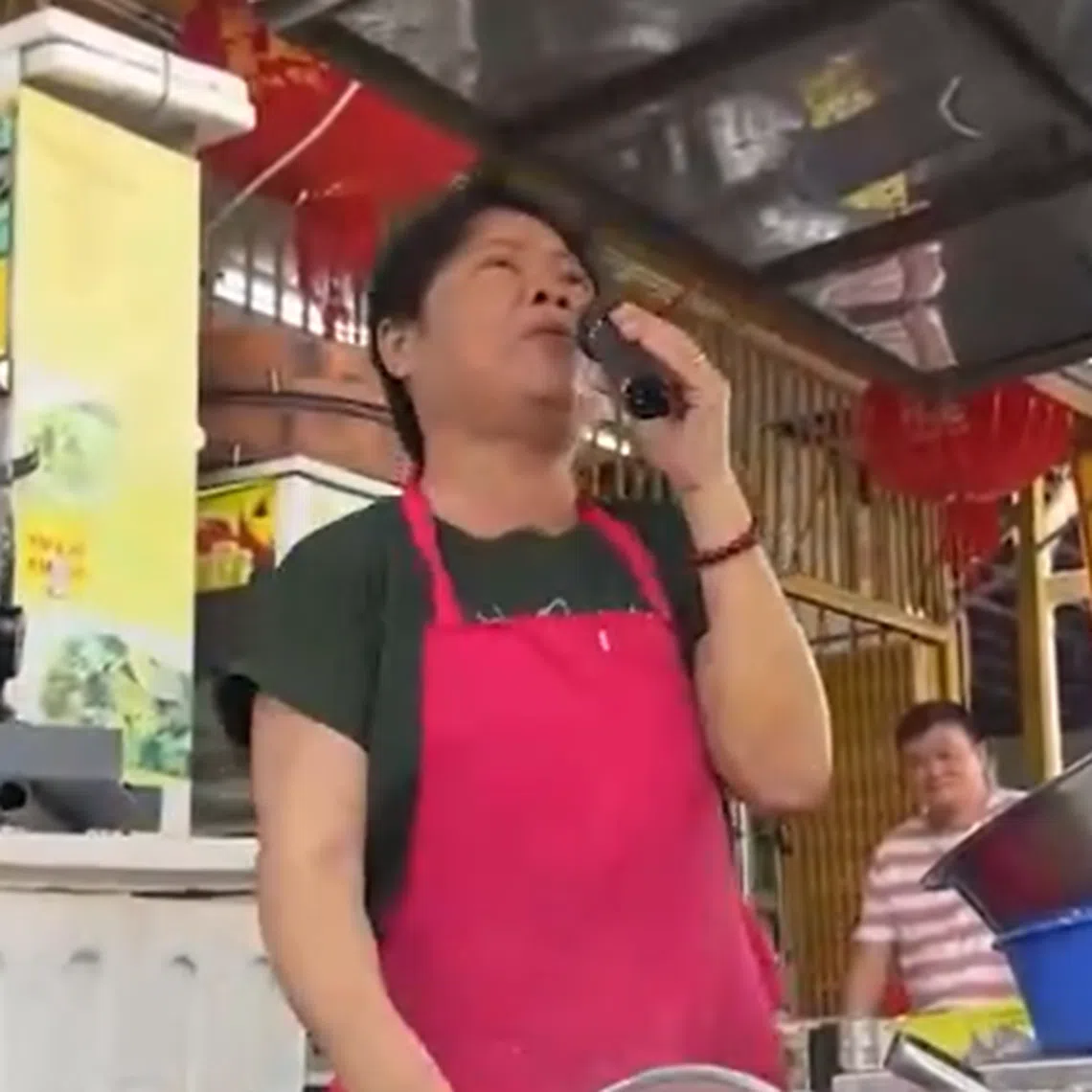 Ms Lye Chooi Ngoh entertains marketgoers in Penang with classic tunes while selling fried snacks at her roadside stall.