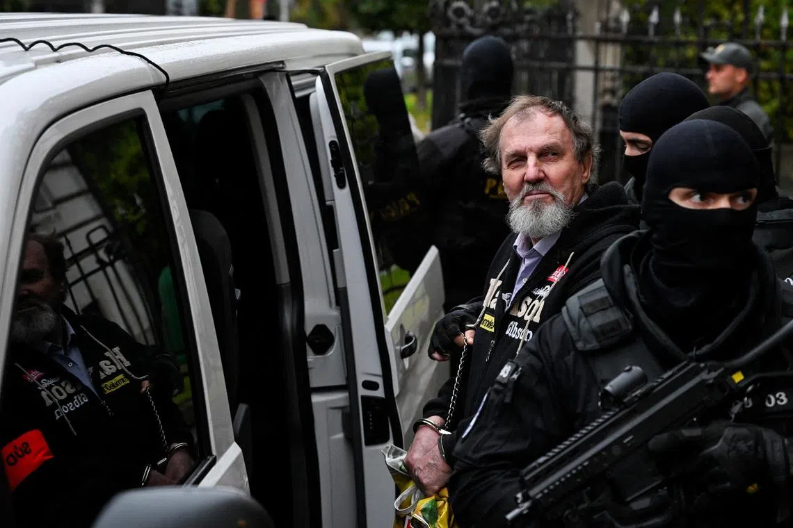 Juraj Cintula, accused of the 2024 attack on Slovak Prime Minister Robert Fico, gets into a car with security officials after the verdict on the final day of his trial, at the Specialised Criminal Court in Banska Bystrica, Slovakia, October 21, 2025. REUTERS/Radovan Stoklasa / File Photo