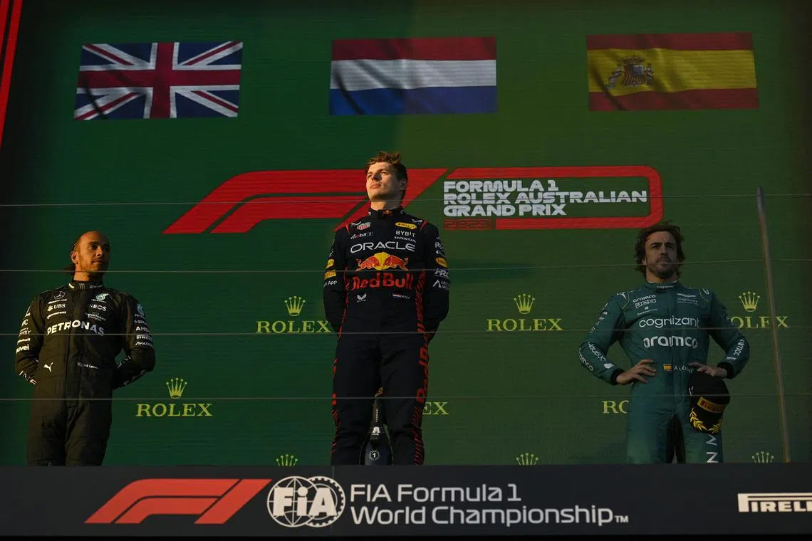 Formula One F1 - Australian Grand Prix - Melbourne Grand Prix Circuit, Melbourne, Australia - April 2, 2023
Red Bull's Max Verstappen celebrates on the podium after winning the Australian Grand Prix along with second placed Mercedes' Lewis Hamilton and Aston Martin's Fernando Alonso REUTERS/Jaimi Joy