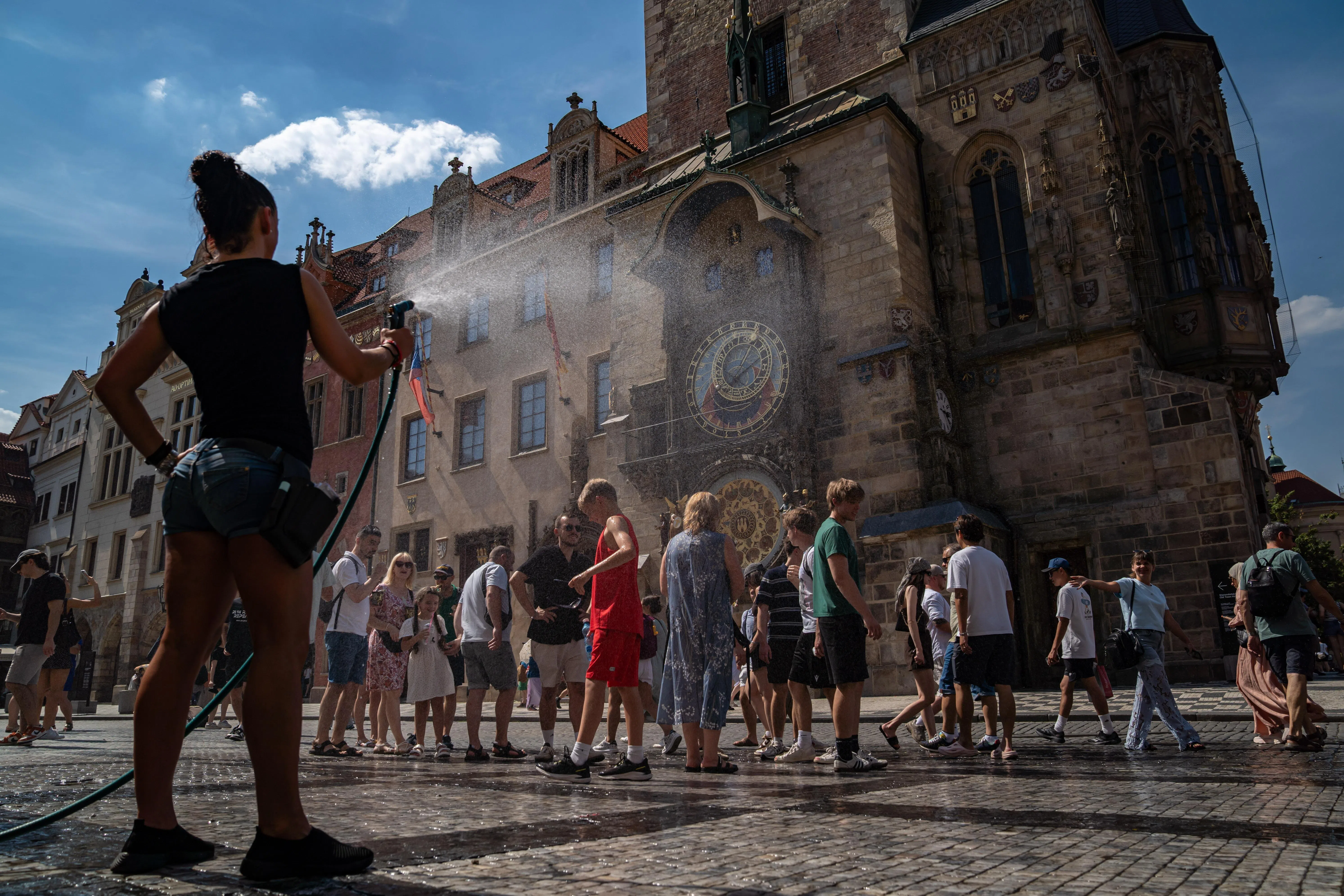 epa13069052 A restaurant staff member sprays people with water to help cool them off during a hot, sunny day at Old Town Square in Prague, Czech Republic, 27 June 2026. According to meteorologists, temperatures in the Czech Republic reached 40 degrees Celsius for the first time since 2012, as readings continued to rise. A record set 20 August 2012 was also broken at one location in the northern part of the country, where 40.6 degrees Celsius was measured. EPA/FADI YOUSEF