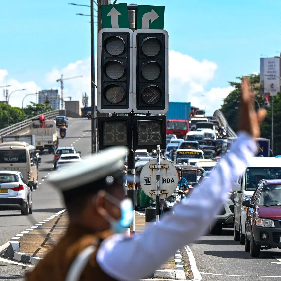 Commuters ride past inoperative traffic lights following a nationwide electricity blackout in Colombo on Oct 17.