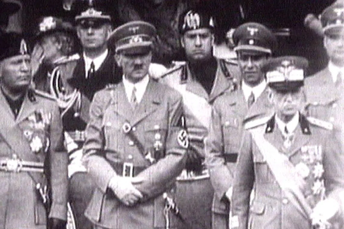 FILE PHOTO: King Victor Emanuel III, (R) Adolf Hitler (C) and Benito Mussolini (L) watch fascist troops march past from a balcony in central Rome in this 1941 television file footage/File Photo