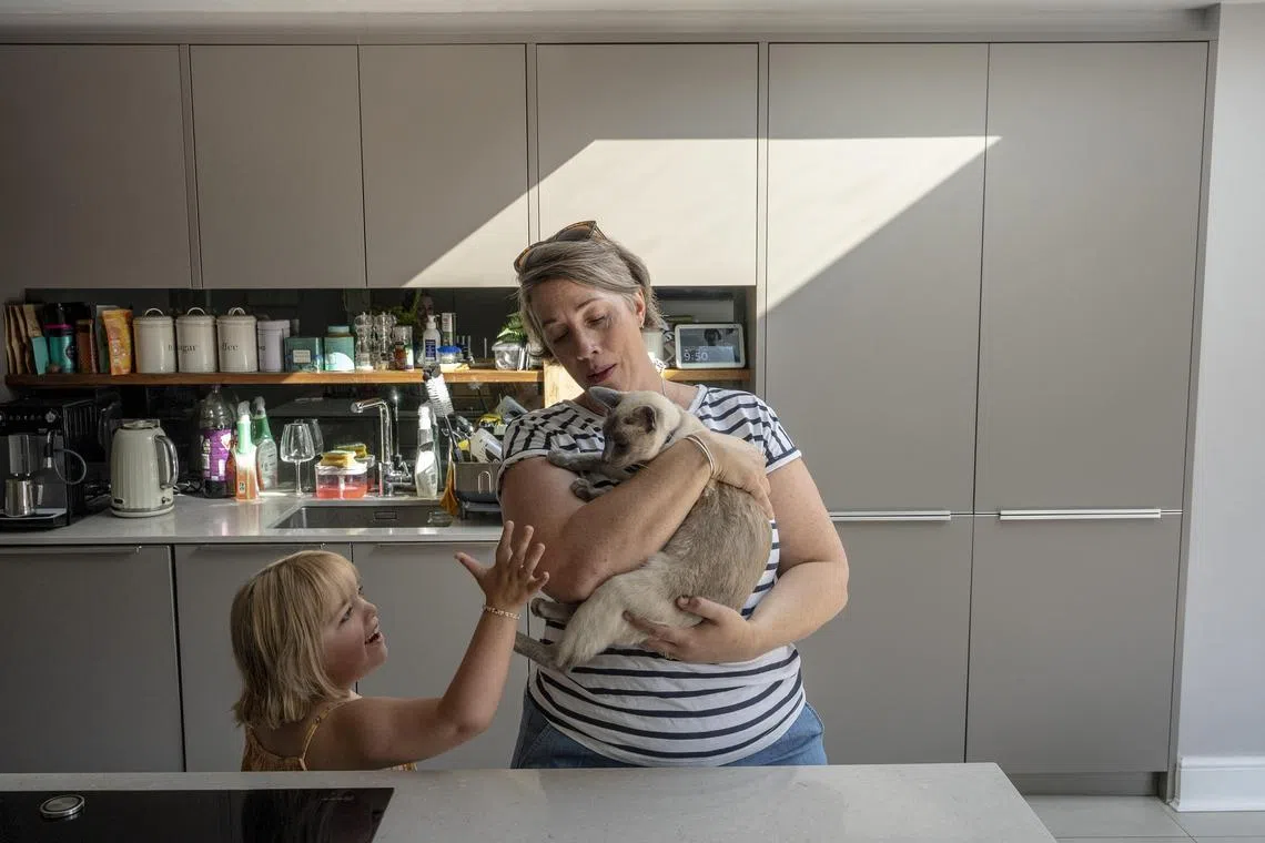 Helen Burness with her daughter Marigold at their home in Purley, south London on Sept. 7, 2023. More than 100 schools have had to shut or close areas off because of dangerous lightweight concrete, leaving many parents, especially those whose children have special needs, scrambling for care. (Andrew Testa/The New York Times)