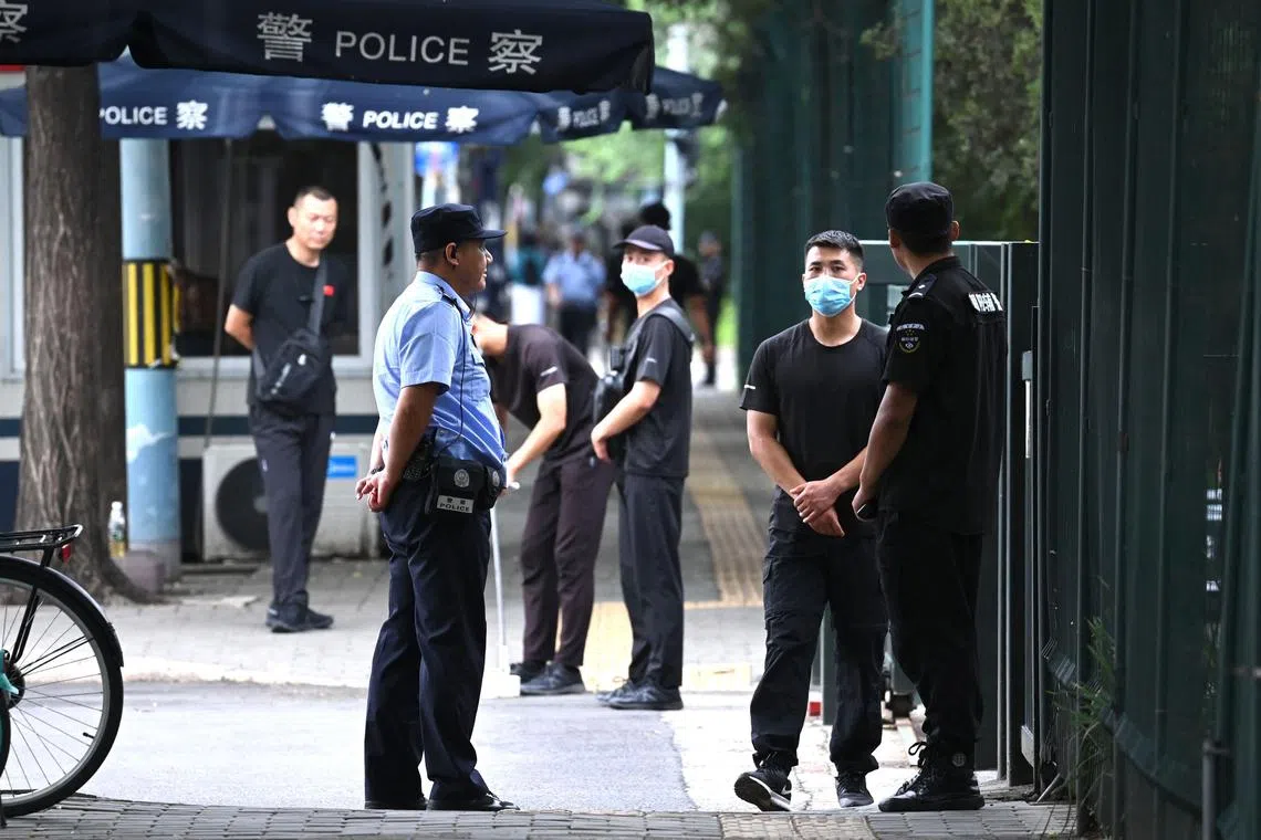 Police and security personnel stand outside the entrance of the Japanese embassy in Beijing on  August 26, 2023. Security has been increased at the embassy since the release of waste water at the Fukushima nuclear plant in Japan on August 24. (Photo by GREG BAKER / AFP)