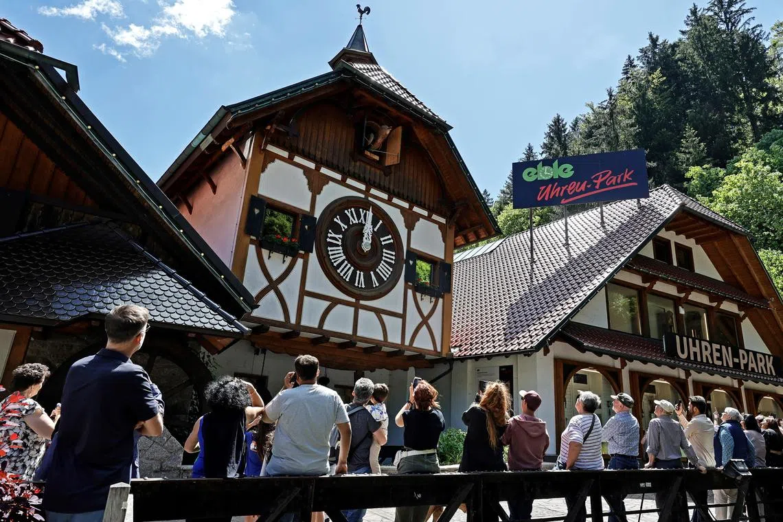 Tourists take pictures of the world's largest cuckoo clock in Triberg in the Black Forest region of Germany on June 10.