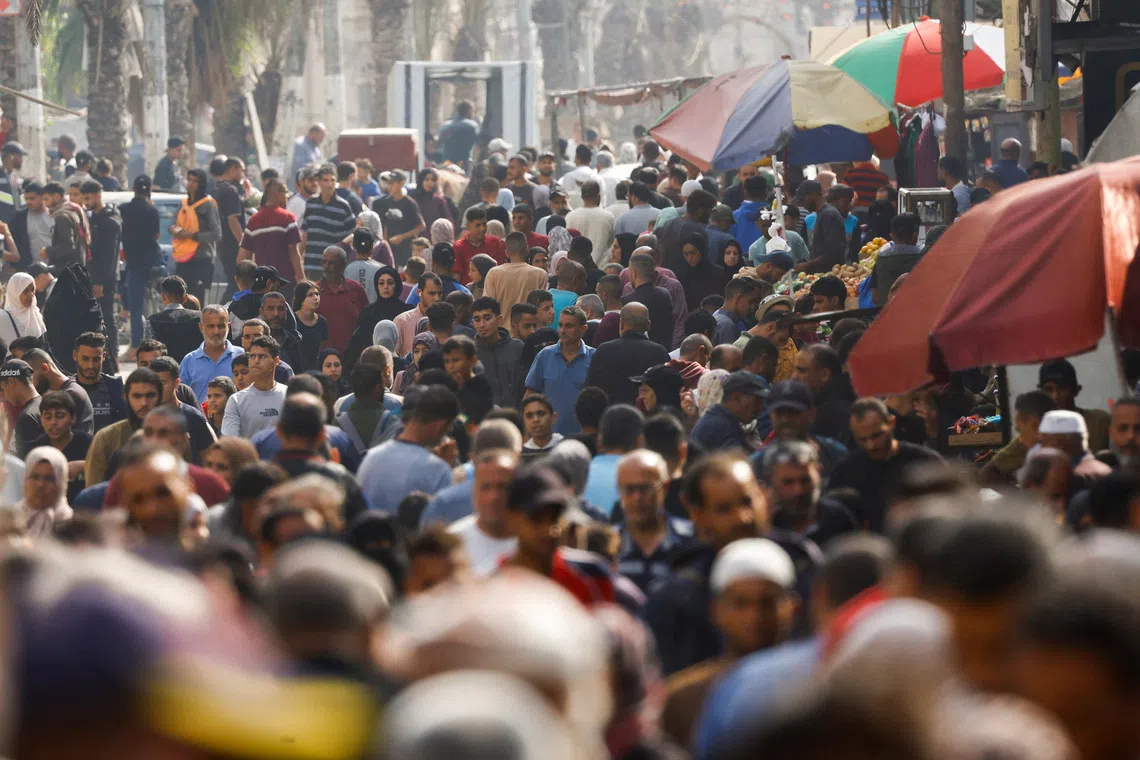 People gather and shop at a local market, in Nuseirat, central Gaza Strip, November 13, 2025. REUTERS/Mahmoud Issa