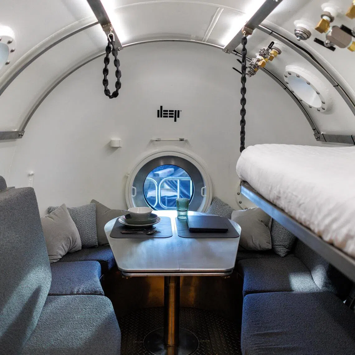 An interior view of the bedroom of the Vanguard subsea human habitat displayed in a warehouse.